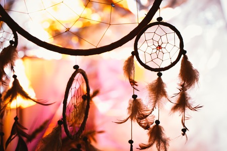 black and white photo of a dream catcher at sunset purple dark background.の写真素材