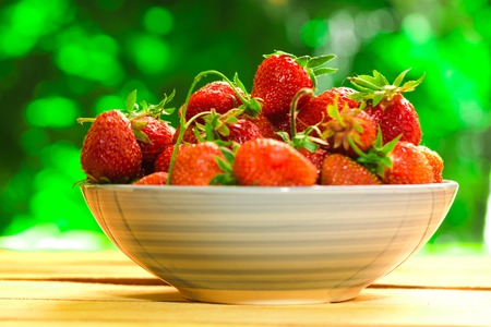 fresh strawberries in a blue plate on a blurred background.の写真素材