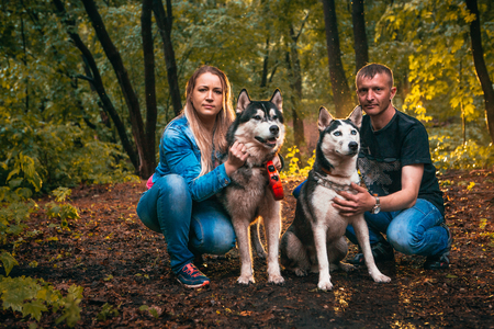 family with husky dogs in the forest.の写真素材