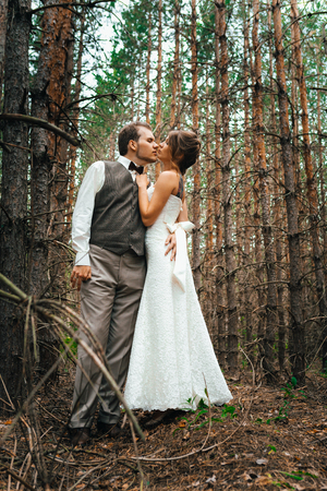 dramatic picture bride and groom on the background of leaves and forest backlight.の写真素材