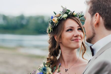 young groom and bride standing and hugging on the background of the river.