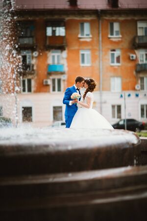 Bride and groom near the fountain in the summer.の写真素材