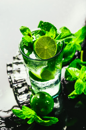 glass of mojito with lime and mint close-up ice cube on a dark background.の写真素材