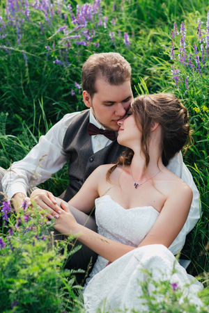 portrait of the bride and groom resting on a lavender background.の写真素材