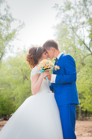 bride and groom standing and kissing in the background of the nature.の写真素材
