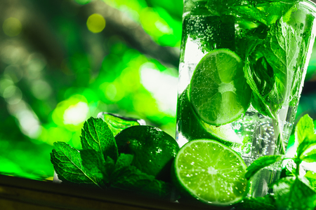 glass of mojito with lime and mint close-up ice cube on a dark background.の写真素材