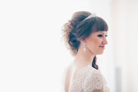 young bride smiling and standing near a window.の写真素材