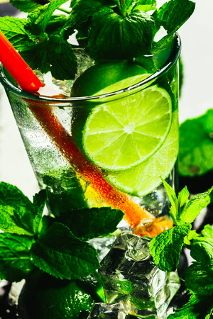 glass of mojito with lime and mint ice cube close-up with red straw.の写真素材