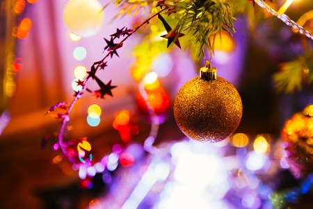Golden ball  on a background of green Christmas tree branchesの写真素材