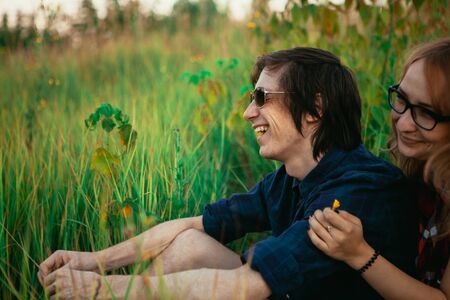 guy and the girl sitting in the grass.の写真素材