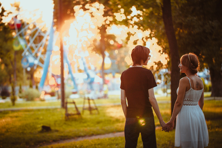 guy and the girl hugging at amusement background.の写真素材