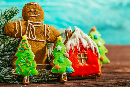 painted gingerbread house, Christmas tree and the man on a blue background.