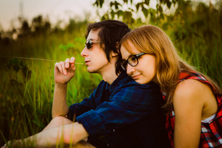 guy and the girl sitting in the grass.の写真素材