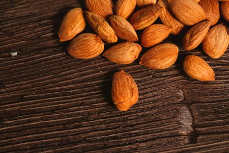 Apricot kernels are scattered on the wooden backgroundの写真素材