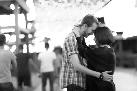 black and white photo happy loving couple in the evening against the background of light garlandsの写真素材