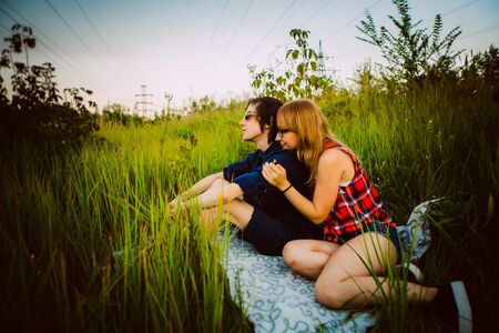 guy and the girl sitting in the grassの写真素材