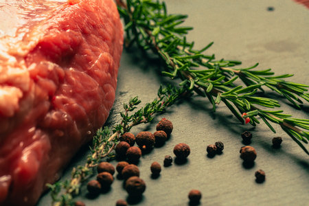 raw pork meat with spices on slate stone kitchen boardの写真素材