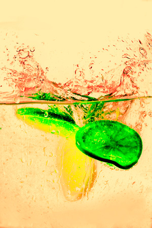 orange halves falling into water on infrared filter.の写真素材