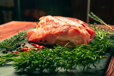 raw pork meat with spices on slate stone kitchen board.の写真素材