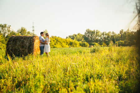 love story man and woman on the background of haystacks and sun.の写真素材