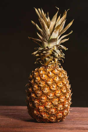 Pineapple is on the table on a dark background.の写真素材