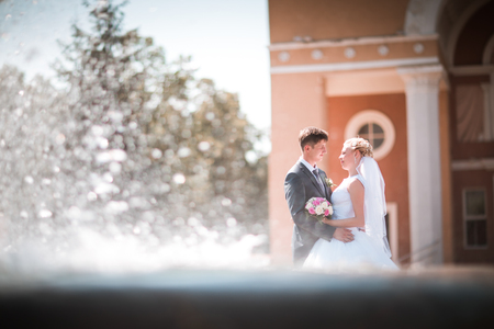 the bride and groom on the background of a fountainの写真素材