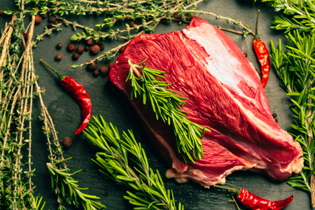 raw beef meat with spices on slate stone kitchen boardの写真素材