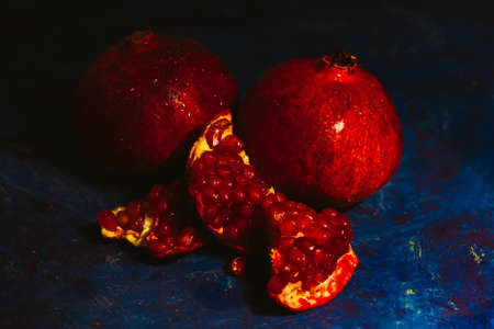 red sliced pomegranate on a blue abstraction backgroundの写真素材