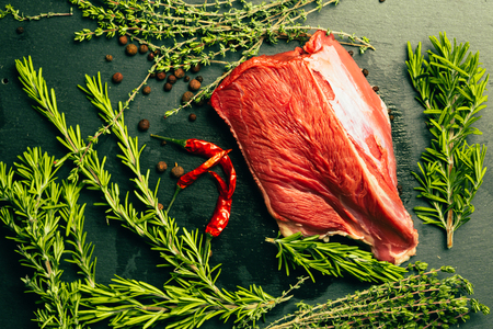 raw beef meat with spices on slate stone kitchen boardの写真素材
