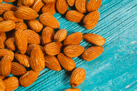 handful of almonds on a blue wooden backgroundの写真素材