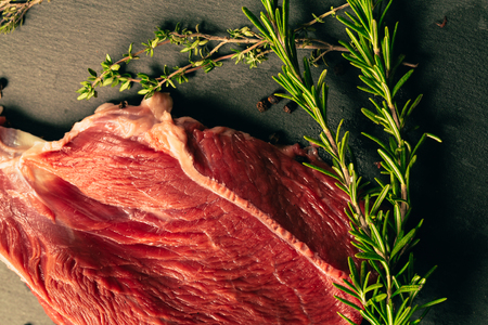 raw beef meat with spices on slate stone kitchen boardの写真素材