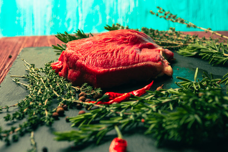 raw beef meat with spices on slate stone kitchen boardの写真素材