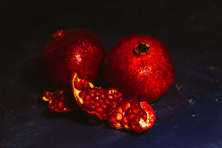 red sliced pomegranate on a blue abstraction backgroundの写真素材