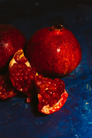 red sliced pomegranate on a blue abstraction backgroundの写真素材