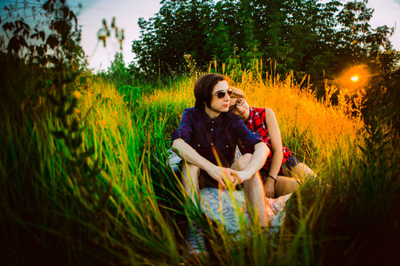 guy and the girl sitting on a background of grassの写真素材