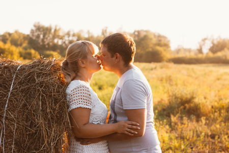 love story man and woman on the background of haystacks sunの写真素材