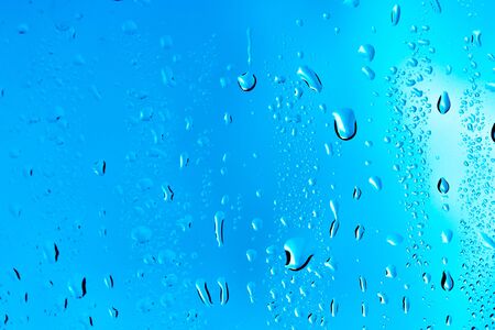 Drops on the glass rain blue backgroundの写真素材