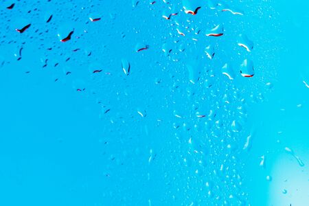 Drops on the glass rain blue backgroundの写真素材