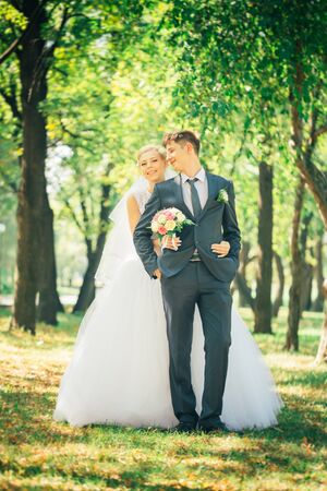 portrait the bride and groom on the background of the park alleyの写真素材