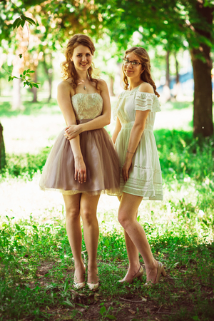 Two beautiful girlfriends on a plant backgroundの写真素材