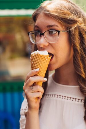 Young beautiful girl eating ice creamの写真素材