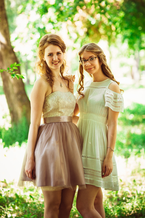 Two beautiful girlfriends on a plant backgroundの写真素材
