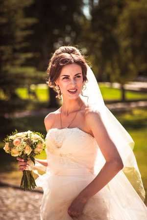 The beautiful brunette bride on a walk in parkの写真素材