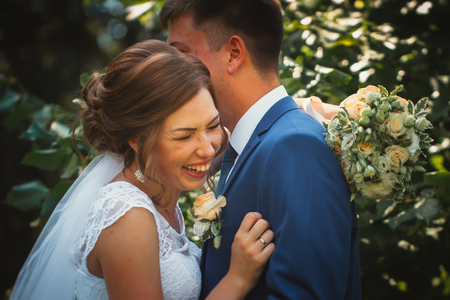 couple groom and bride hugging and kissing on nature park backgroundの写真素材