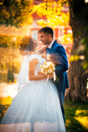 couple groom and bride against the background of orange leavesの写真素材