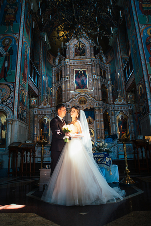young couple groom and bride on church backgroundの写真素材