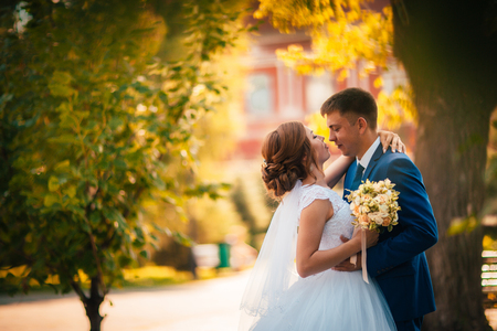couple groom and bride against the background of orange leavesの写真素材
