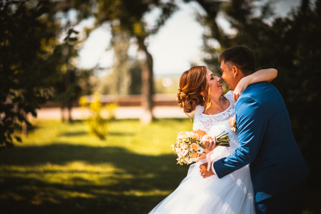 couple groom and bride against the background of orange leavesの写真素材