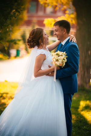 couple groom and bride against the background of orange leavesの写真素材