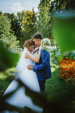 couple groom and bride hugging and kissing on nature park backgroundの写真素材